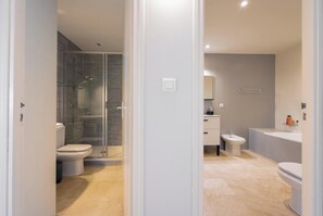 Ein modernes Badezimmer mit Duschkabine aus Glas, Toilette, Bidet und Waschbecken.