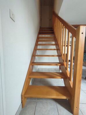 A wooden staircase with a handrail, leading to an upper floor. - Townhouse with a terrace and garden, 180 m from the lock. (Tinténiac)