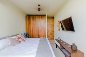 A hotel room with a bed, bedside table, and a mirror on the wall. - Huachinango 34 by Homirent (Cancún)
