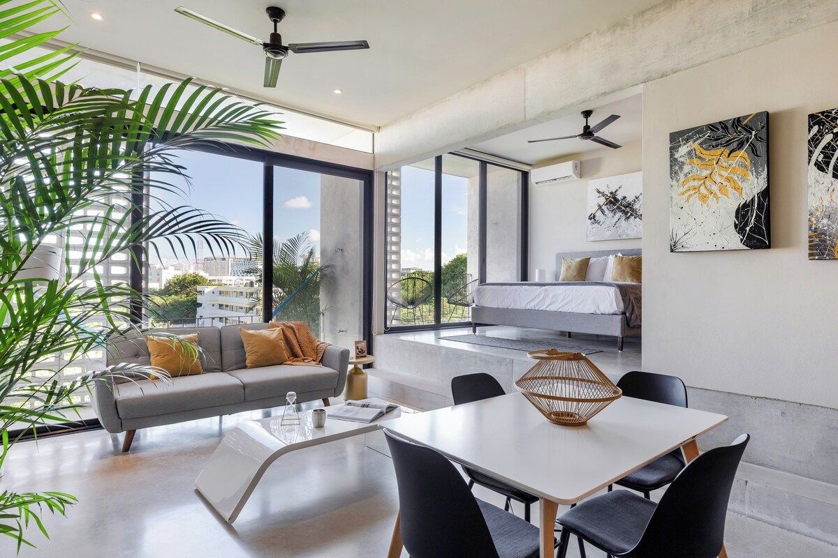 A modern living space with a sofa, dining table, and artwork on the walls.