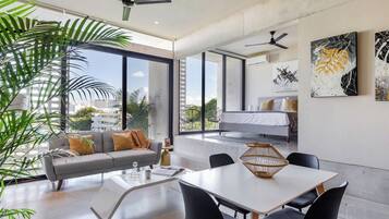 A modern living space with a sofa, dining table, and artwork on the walls.