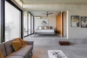 A modern bedroom with a bed, a ceiling fan, and artwork on the walls. - Huachinango 34 by Homirent (Cancún)
