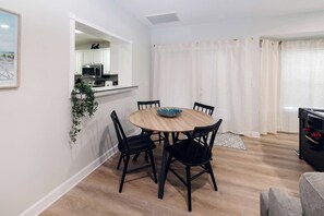 A dining area with a round table, black chairs, and a bowl. - Private Pool, Pickleball, Mini Golf, Game Room (Bradenton)
