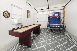 A room with a foosball table, a dartboard, and a basketball hoop. - Private Pool, Pickleball, Mini Golf, Game Room (Bradenton)