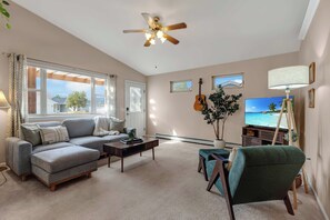A living room with a sofa, coffee table, TV, guitar, and ceiling fan. - 3BR 2 Bath Ranch-style house in Salida - Sleeps 7 (Salida)