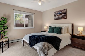 A bedroom with a bed, two bedside tables, a nightstand, a window with blinds, a ceiling fan, and a wall-mounted picture. - 3BR 2 Bath Ranch-style house in Salida - Sleeps 7 (Salida)
