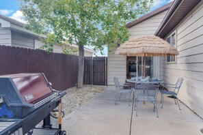 A backyard with a barbecue grill, a dining table with chairs, and a thatched umbrella. - 3BR 2 Bath Ranch-style house in Salida - Sleeps 7 (Salida)