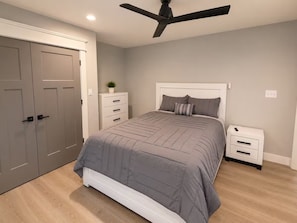 A bedroom with a bed, a nightstand, a ceiling fan, and a wardrobe. - Lake Cumberland Views by Lee’s Ford Marina 5BR, 3 Decks, Sleeps 10, Pet Friendly (Nancy)