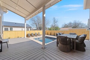 A covered outdoor deck with a pool, lounge chairs, and a table with chairs. - Gloria Estate- 2 blocks to Silos (Waco)