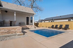 A residential backyard with a swimming pool, a covered patio with outdoor furniture, and a wooden fence. - Gloria Estate- 2 blocks to Silos (Waco)