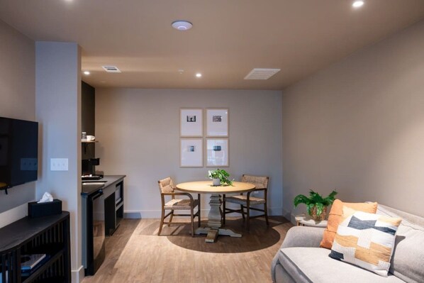 A compact living space with a dining area, kitchenette, and seating area.