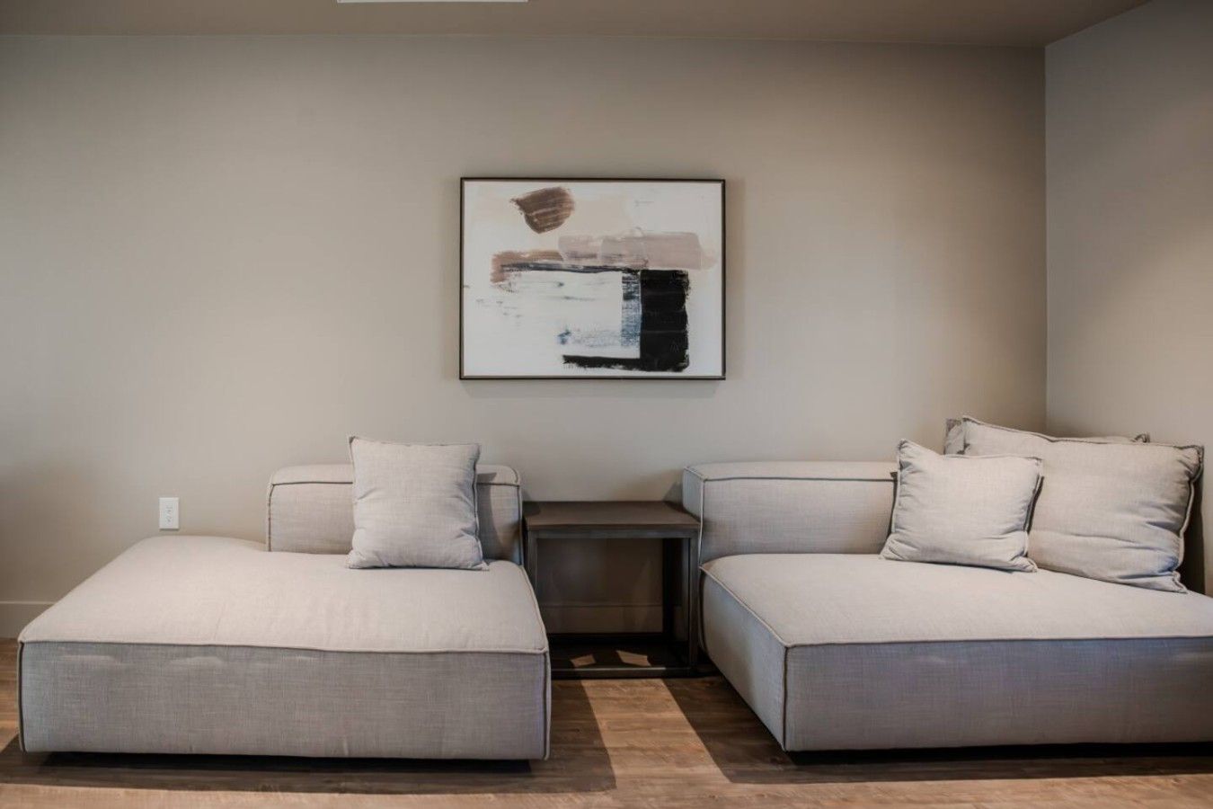 A modern, minimalist room with a sectional sofa and a small side table.