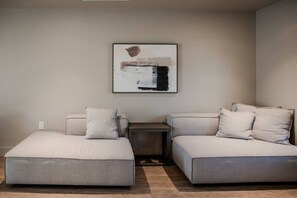 A modern, minimalist room with a sectional sofa and a small side table.