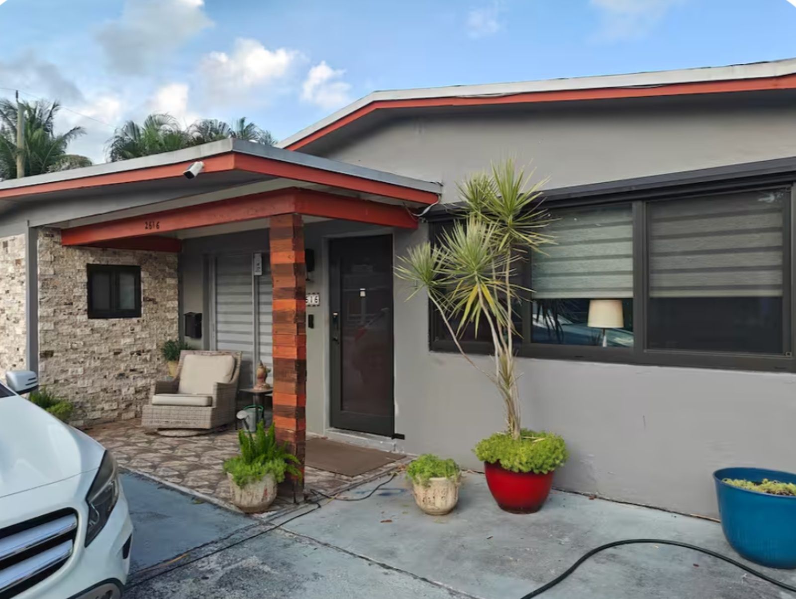 A modern house with a covered porch, a door, and a window.