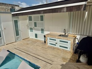 A poolside area with a built-in sink and storage cabinets. - Villa Valmira | private pool (Canóvanas)