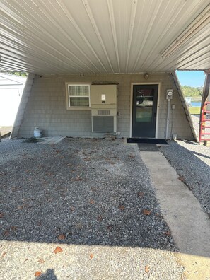 A small, single-story building with a sloped roof, a front door, and a window. - 3-bedroom cottage on the water in peaceful Hollywood with AC for relaxing stays (Hollywood)