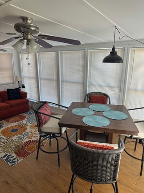 A dining area with a table, chairs, and a ceiling fan. - 3-bedroom cottage on the water in peaceful Hollywood with AC for relaxing stays (Hollywood)