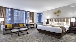 Een hotelkamer met een groot bed, een bank, een bureau en een stoel.