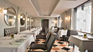 Een restaurant met lange tafels, stoelen en een geruit vloertapijt.