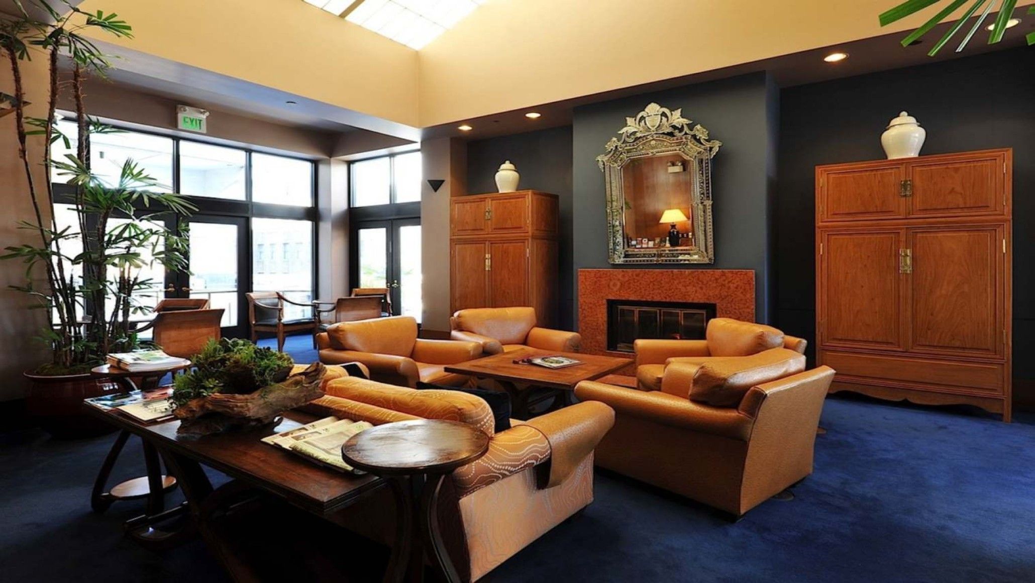A lobby with leather sofas, a fireplace, and wooden cabinets.