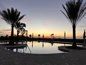 A serene pool area with palm trees and a sunset view. - Sweet 'N Salty (Port St. Joe)