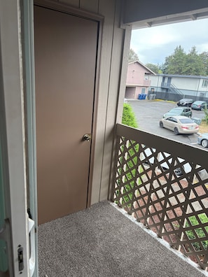 A balcony with a view of a parking lot and buildings. - Comfortable 2Bed 1Bath Condo in Auburn (Auburn)