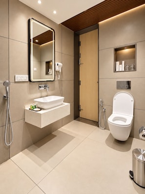Un baño moderno con un espejo grande, un lavamanos blanco, un inodoro y una ducha.