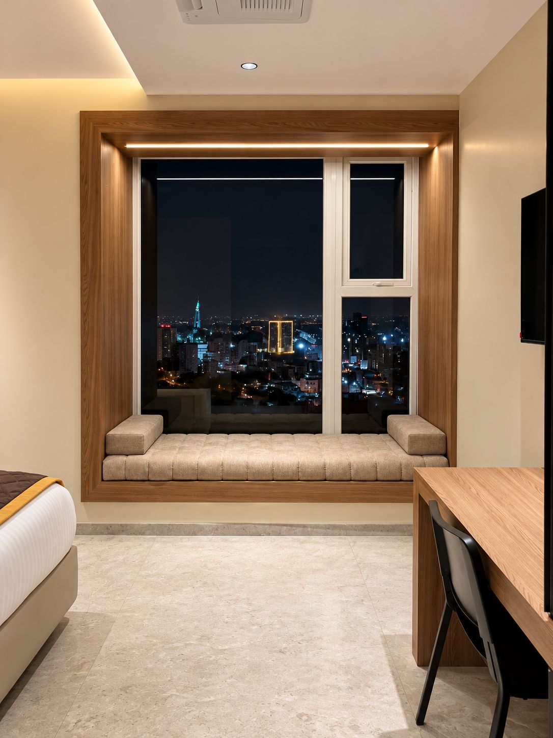 Ein modernes Hotelzimmer mit großem Fenster, einem Bett, einem Schreibtisch und einem Stuhl.