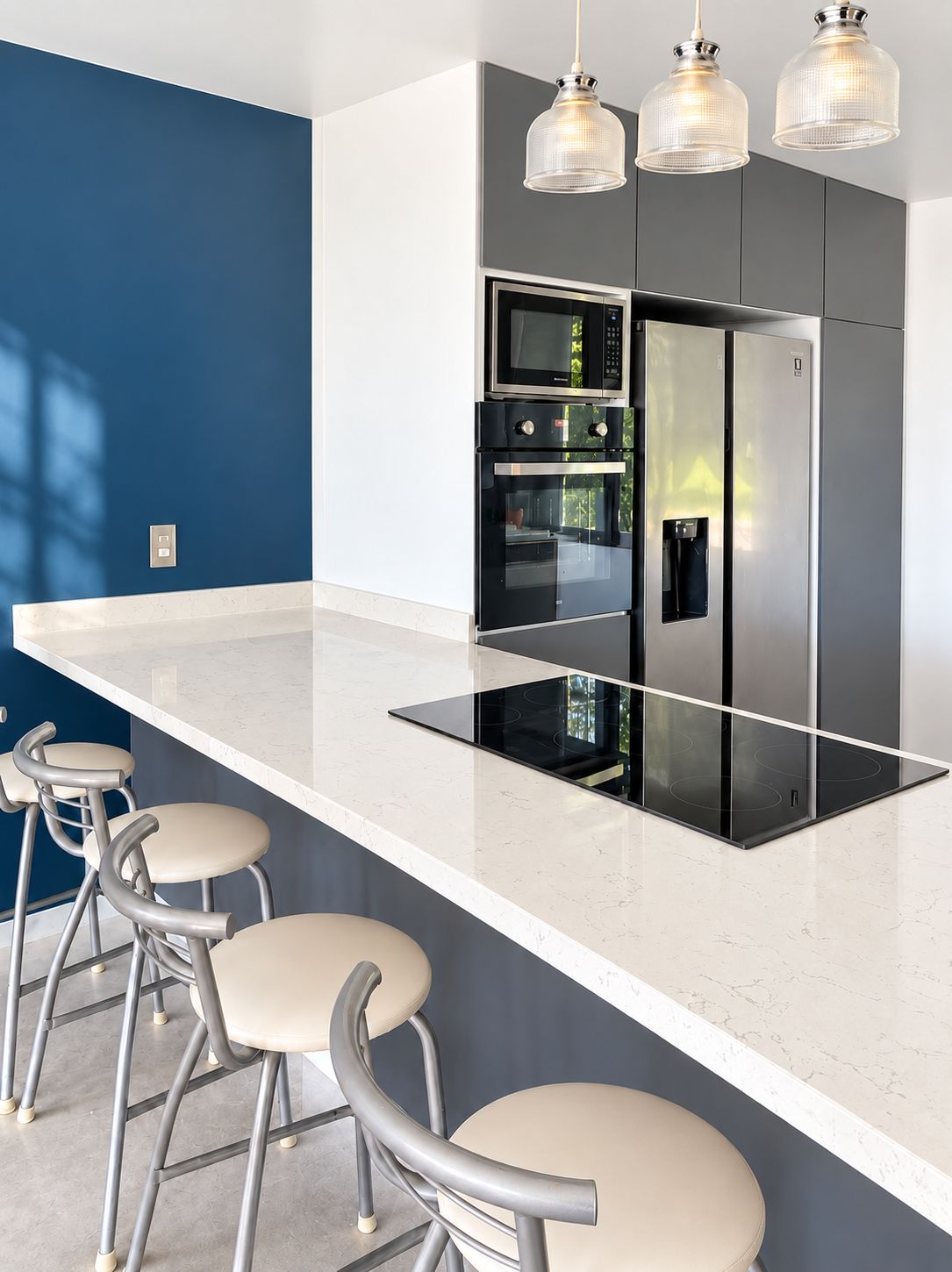 A modern kitchen with a central island, stainless steel appliances, and bar stools.
