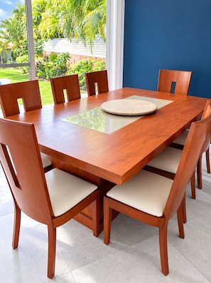 Un tavolo da pranzo rettangolare in legno con sei sedie, ognuna dotata di seduta imbottita.