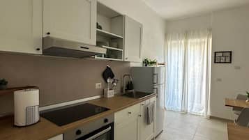 Eine moderne Küche mit weißen Schränken, einem Backofen und einem Spülbecken.