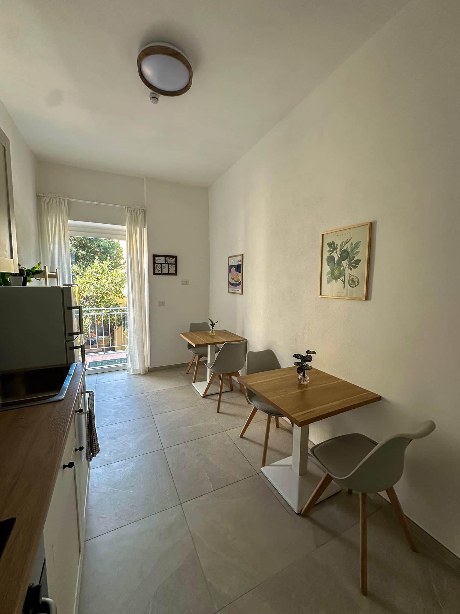 A modern kitchen with a built-in oven and a dining area with a wooden table and chairs.