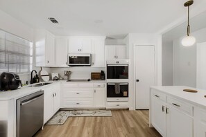 A modern kitchen with white cabinetry, a built-in microwave, a stove, and a dishwasher. - Spacious 4-bedroom house in enjoyable Plano (Plano)