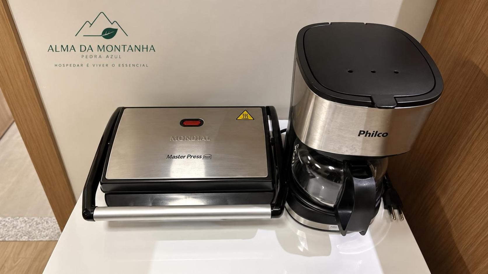 A coffee machine and a water dispenser on a white countertop.
