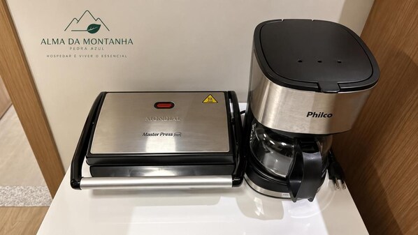 A coffee machine and a water dispenser on a white countertop.