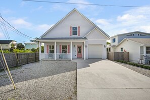 A two-story residential house with a front porch, a garage, and a gravel driveway. - Walk to Beach • Heated Pool • 3 King Beds • Boat Ramp • St. Augustine (St. Augustine)