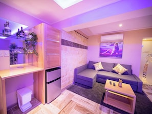 A compact living space with a kitchenette, a sofa set, and a flat-screen TV mounted on the wall. - Luxury Villa With Pool, Jacuzzi & Beach Access (Sosúa)