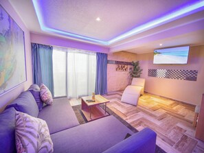 A modern living room with a sofa, a coffee table, and a TV mounted on the wall. - Luxury Villa With Pool, Jacuzzi & Beach Access (Sosúa)
