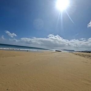Ein Strand mit blauem Himmel und Sonne.