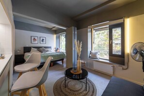 Ein modernes Schlafzimmer mit Bett, Nachttisch, Lampe und einem Kunstwerk an der Wand.