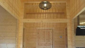 A wooden interior with a door, a fire extinguisher, and a stove.