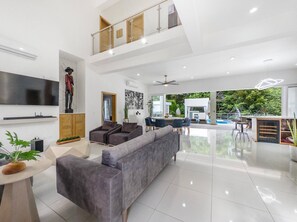 A spacious living area with a grey sofa, a flat-screen TV, and a statue. - Luxury Boss Villa in Sosua Hispaniola (Sosúa)