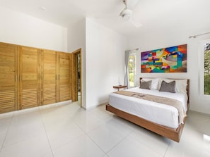 A bedroom with a bed, wooden wardrobe, and a ceiling fan. - Luxury Boss Villa in Sosua Hispaniola (Sosúa)