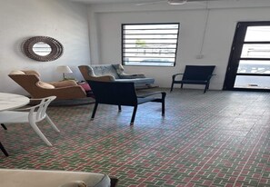 A room with a patterned floor, a round mirror, a sofa, a chair, and a table. - Apartments, 2 Bedrooms, Near Old San Juan-12 (San Juan)