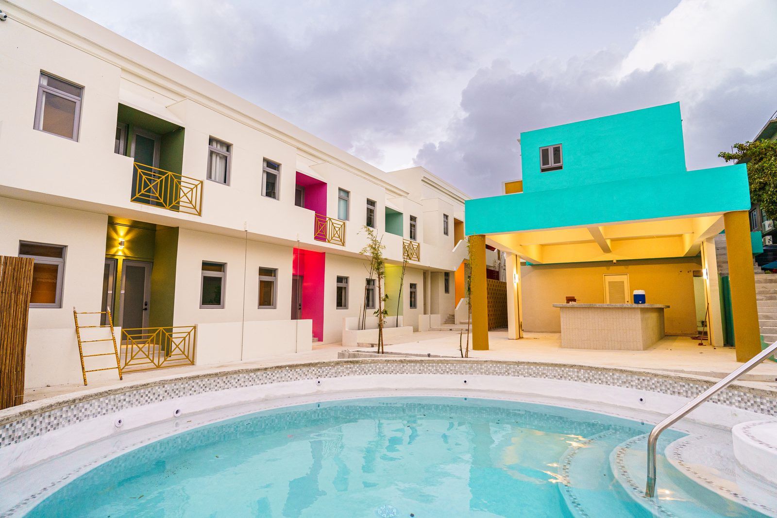 Un hôtel doté d’une piscine, d’un espace de réception et d’un bâtiment à plusieurs étages avec des balcons.