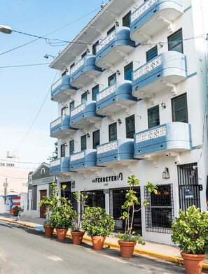 A multi-story building with balconies, a sign reading 'LA FERRETERIA 200', and potted plants along the sidewalk. - Apartments, 2 Bedrooms, Near Old San Juan-17 (San Juan)