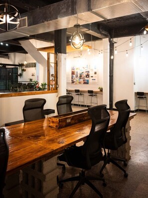 A conference room with a wooden table, black chairs, and a hanging light fixture. - Apt with Balcony Near Old San Juan - 2 (San Juan)