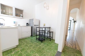 A kitchen with white cabinets, a refrigerator, a coffee maker, and a table with stools. - Apt with Balcony Near Old San Juan-7 (San Juan)