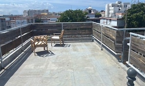 A rooftop terrace with a concrete floor, metal railings, and two wooden chairs. - Apt with Terrace near Beaches & Old San Juan-15 (San Juan)