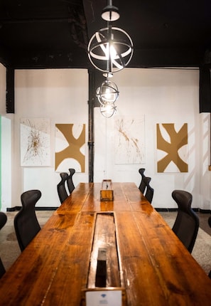 A conference room with a long wooden table, black chairs, and abstract wall art. - Apt with Terrace near Beaches & Old San Juan-21 (San Juan)
